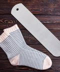 Aluminum Sock Jig Set For Sublimation 17.71 Inch 4 Pack next to striped socks on a wooden background