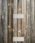 Wooden fence with two Five Pack Heavy Duty Stainless Steel Straight Brace Brackets For Wood Perfect Mending Plates with openings.