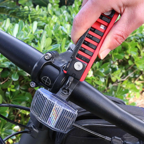 Using 7 In 1 Bike Multitool With Hex Wrenches And Screwdrivers, Ruler, on a bicycle handlebar for on-the-go maintenance