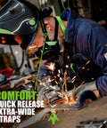 Worker wearing half face respirator with replaceable twin filters for dust protection, 99.99 percent filtration, using welding tool