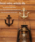 Badass Vintage Cast Iron Nautical Anchor Wall Hooks For Bathrooms And Closets. Two hooks in black and gold on wooden wall.