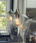 One Light Brushed Nickel Mini Pendant With Clear Seeded Glass Shade Sloped Ceiling Compatible Hanging Light in kitchen