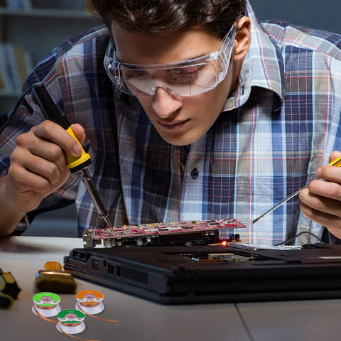Person soldering a PCB with Six Piece Solder Wick Braided No Clean Desoldering Wicks Set in multi color for electronics repair.