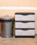 Space Saving 3 Tier Resin Storage Cabinet With Drawers For Garage Office Home And Laundry Room Gray With Charcoal Trim Fully Assembled next to a trash can