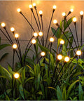 Two Pack Solar Garden Lights With 12 LED Firefly Lights illuminating garden at night, weatherproof, swaying on flexible poles.