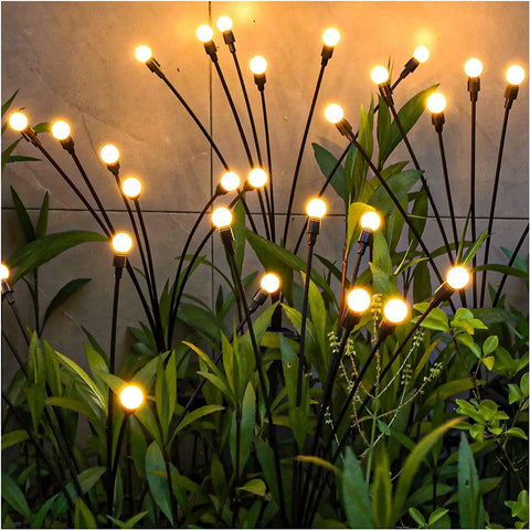 Two Pack Solar Garden Lights With 12 LED Firefly Lights illuminating garden at night, weatherproof, swaying on flexible poles.