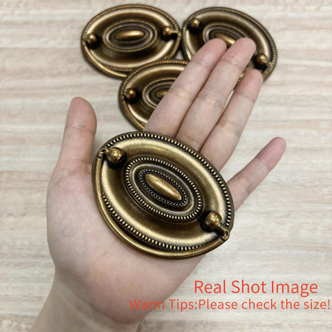 Person holding 4 Pcs Antique Brass Bail Drawer Pulls Oval Drop Swing Handles For Dresser And Cabinet, Zinc Alloy Hardware, 2.32 Inch Hole