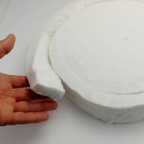 Front view of white ceramic fiber blanket disk with torn edge for high-temperature gasketing