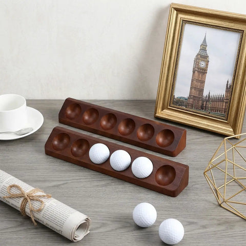 Two Pack Walnut Golf Ball Holder Display Case With Wall Mount Or Tabletop Stand For 12 Standard Balls on a desk, three balls placed.