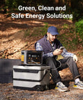 Man using FlashSpeed 600 Portable Power Station 499Wh LiFePO4 Battery beside solar panels in forest campsite