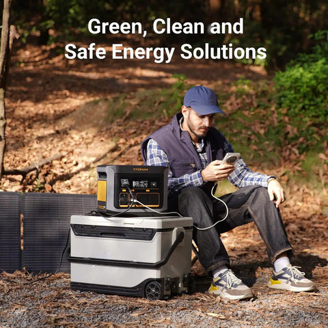 Man using FlashSpeed 600 Portable Power Station 499Wh LiFePO4 Battery beside solar panels in forest campsite