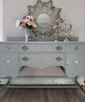 Gray dresser painted with Manatee Gray Chalk Finish Furniture Paint for DIY Lovers, showcasing matte mineral finish and decor details.
