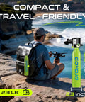 Man with backpack sitting on cliff near ocean holding drone; Compact 0.5L Mini Scuba Tank Backup Air For Snorkeling And Training visible