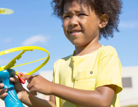 Child playing with Skyrocopter Light Up Flying Disc With Launcher For Kids 5 And Up, Disco Flyer That Shines At Night outdoors