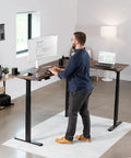 Man working at Electric Triple Motor Height Adjustable Corner Desk Frame For L Shaped Setup With 3 Legs Sit Stand Ergonomic Frame Up To 300 Lbs Black Frame Only DESK V130EB