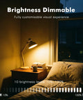 Rechargeable E26 Magnetic Detachable Light Bulb With Remote in dimmable mode on desk lamp by bed, nighttime setting.
