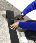 Person cutting Heavy Duty 4 Inch Anti Slip Tape 35 Ft Roll With 80 Grit Friction For Indoor And Outdoor Stairs Traction Non Skid Waterproof Grip Tape Black