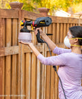 Woman using iSpray Front End Nozzle For HVLP Sprayers Broad Interior And Exterior Coverage With Unthinned Coatings on fence