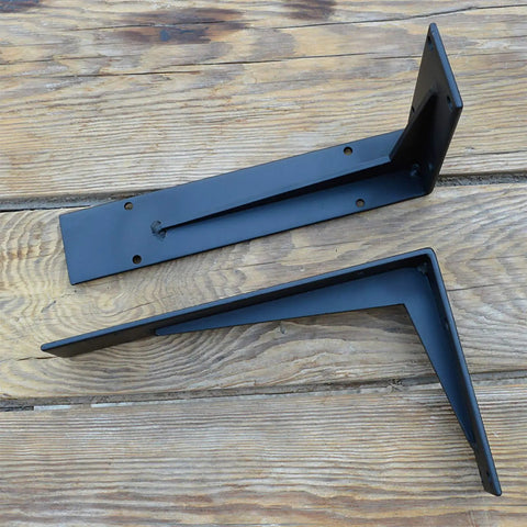 Heavy Duty Farmhouse Shelf Brackets Badass Rock Solid Iron Wall Mounts Black Metal Industrial L Braces on wooden surface.