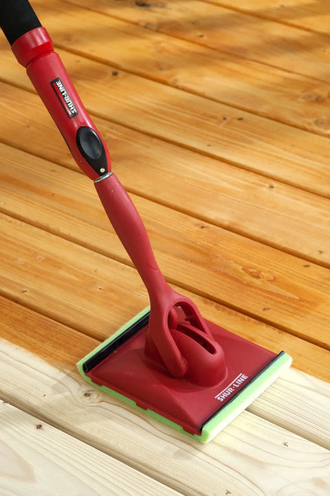 Deck Stain Pad With Groove Tool For Even Coverage On Flat Surfaces And Between Boards with red handle on wood deck