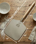 Pizza Peel 12 By 14 Aluminum Paddle with 21 Inch Detachable Wooden Handle, 35.5 Inch Total Length on wooden table.