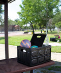 Big Time Heavy Duty Collapsible Storage Bin With 16 Gallon Capacity, Folds Flat Easy, holding sports balls in a park setting.