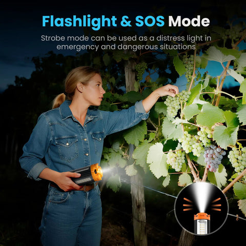 A person using an orange rechargeable outdoor camping light with remote to illuminate grape vines, showing flashlight and SOS mode.