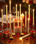 Flameless LED Taper Candles Bulk 48 Pack Battery Operated Realistic Flicker for Wedding Church Graduation Party Home Decor Ivory Classic Style Fits Standard Holders Requires Two AAA Batteries Not Included on table with rose petals and decorations.