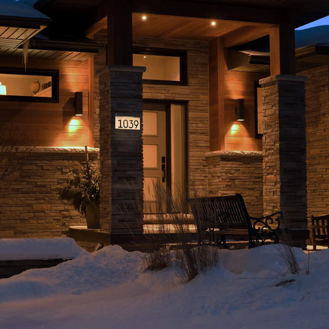 Solar Powered LED Address Sign For Outdoor Use With 3000K Warm White Light on house wall at night, showing illuminated numbers.