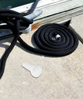 Marine Thru Hull Drain Outlet For Boats And Yachts with coiled black rope on dock