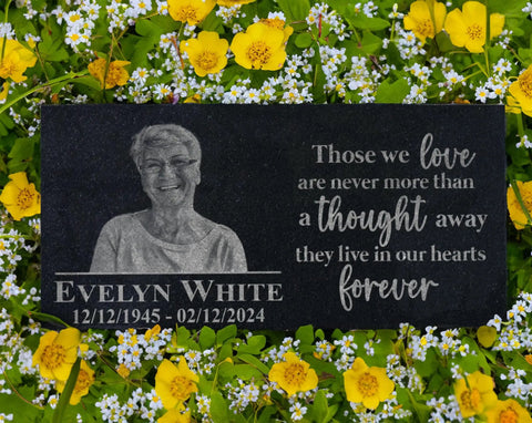 Custom Black Granite Memorial Stone With Your Image For Outdoor Garden And Cemetery Use Personalized Headstone Or Grave Marker Plaque Durable Outdoor Memorial Tablet Forever Keepsake For Loved Ones, featuring engraved portrait and text, placed among flowers.