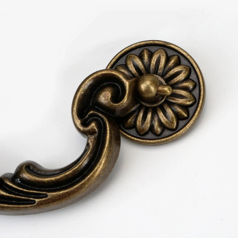 Close-up of zine alloy drawer pull with floral motif, part of Four Piece 150mm Center Drawer Pull Handles in Antique Yellow Bronze Finish.