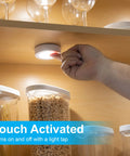 Touch-activated use of Under Cabinet LED Puck Lights Wireless Battery Operated Stick On Lighting showing bright white light
