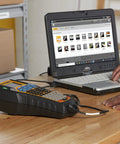 Straight Up Heavy Duty Jobsite Computer Connected Label Maker With Rechargeable Battery connected to laptop on a workspace.