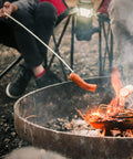 Person using 45 Inch Extra Long Marshmallow Roasting Sticks Kit For Campfire Smores, 4 Pack Telescoping Skewers over a campfire