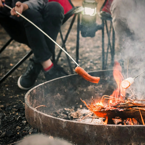 Person using 45 Inch Extra Long Marshmallow Roasting Sticks Kit For Campfire Smores, 4 Pack Telescoping Skewers over a campfire