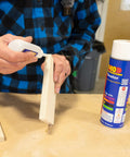 Person applying SoloKit Instant Adhesive And Activator Set For Woodworking Bonds In Ten Seconds to wood piece with activator nearby.