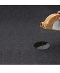 Oil being poured onto the Garage Oil Spill Mat 36 By 59 Inches Dual Layer Absorbent Felt Top With Rubber Backing Waterproof Non Slip Reusable Maintenance Pad