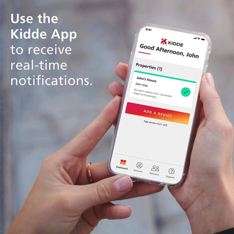 Person holding smartphone showing app for Smart Carbon Monoxide Detector And Indoor Air Quality Monitor 2 In 1 Plug In With WiFi Alexa Compatibility For Real Time Voice Alerts And App Notifications