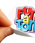 Hand peeling off a sticker with colorful Fun a Ton text design
