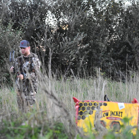 Yellow Jacket Supreme 3 Archery Target Bag Dual Sided 23 By 12 Inches in a field with an archer ready to shoot.