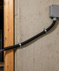 Built Tough Workhorse Corrugated Flexible Conduit Pipe With Compression Fitting Connector For Electrical Cable Routing And Wiring Harness Protection Rated At 20 Bar Pressure In A Sturdy 19 Millimeter Coil installed on a wall with wires visible.