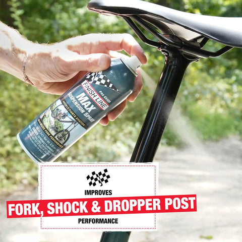 Hand spraying Max Suspension Spray for Bicycles on black dropper post in park, 9 fl oz.