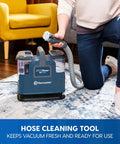 Person using Portable Carpet and Upholstery Spot Cleaner with SixFoot Hose, lightweight design for easy lifts and quick cleanup.