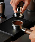 Pro 58 Mm Espresso Powder Distributor With Tough Walnut Handle And Stainless Steel Tines, leveling coffee grounds in a portafilter.