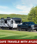 Truck towing a travel trailer through a scenic landscape with trees, promoting safe travels with Ayleid brand.