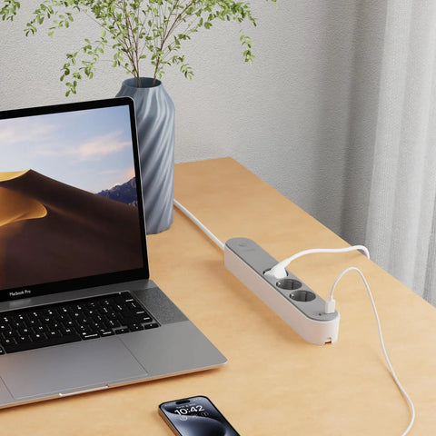 Slick Black Smart Power Strip With WiFi App Control, Heavy Duty Surge Protector, Built In USB Charging Ports on a desk with laptop.