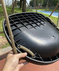 Heavy Duty Swing Seat For Adults And Kids With Weatherproof Ropes, shown close-up in black with hands, outdoor setting