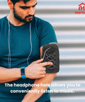 Person using arm strap phone holder with headphone hole for convenient music listening during workout.