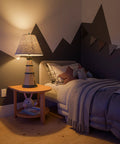 Coastal Nantucket Table Lamp in Antique White Finish, 31 Inch Tall, next to a bed in a cozy nautical-themed room.